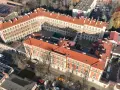 Widok z lotu ptaka na zakład karny Montelupich. Widać budynki z czerwonymi dachami, ogrodzenie z drutem kolczastym i parking. Odwiedziny w zakładzie karnym.