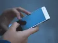 Dłonie trzymają biały smartfon. Czy na dołku można mieć telefon? Tak, nawet w trudnych chwilach można pozostać w kontakcie.