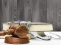 Młotek sędziowski, kajdanki i księga symbolizują zasady prawa karnego.