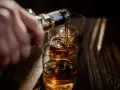 Nalewanie alkoholu do szklanek. Ta scena może symbolizować sprawę w sądzie za picie alkoholu przez nieletnich.