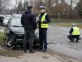 Policjant spisuje zeznania po wypadku. Uszkodzony samochód i ślady na drodze wskazują na poważne zdarzenie, które może skutkować karą za spowodowanie wypadku z uszczerbkiem na zdrowiu.