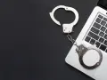 Kajdanki na klawiaturze laptopa, symbolizujące oświadczenie o podjęciu odbywania kary ograniczenia wolności wzór.