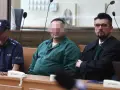 Oskarżony w zielonej koszuli, policjant i prawnik w togach. Czy rozprawa może się odbyć bez oskarżonego?
