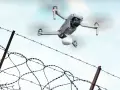 Dron z paczką przelatuje nad drutem kolczastym, niczym rakieta do więzienia dostarczająca przesyłkę.