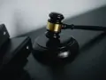 Młotek sędziowski i akta prawne symbolizują sprawiedliwość w sprawach o przestępstwo skarbowe.