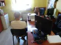 Mężczyzna w białej koszulce siedzi naprzeciwko kobiety przy biurku. To część systemu terapeutycznego odbywania kary.