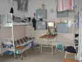 Wnętrze przypomina **zakład karny cela** z łóżkami piętrowymi, stołem, telewizorem i szafkami.