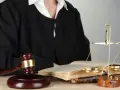 Sędzia w todze, młotek, waga sprawiedliwości i księgi symbolizują prawo i nadzwyczajne środki zaskarżenia.