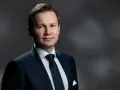 Mężczyzna w garniturze, gotowy do przesłuchania w charakterze świadka.