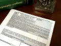 Dokument z pouczeniami do wypełnienia sprzeciwu od wyroku zaocznego lub nakazu zapłaty, obok zielonej księgi "Kodeks postępowania cywilnego".