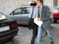 Dwóch mężczyzn, jeden w garniturze, drugi w kurtce i jeansach, idzie obok samochodów. Czy to występek, co to za sytuacja?