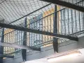 Wnętrze więzienia z siatką zabezpieczającą i prętami, które mogą przypominać, jak wygląda wezwanie do więzienia.