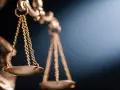 Złota waga Temidy, symbol sprawiedliwości, w blasku światła. Sprawiedliwość waży 15 kkw.