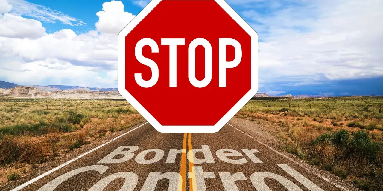 Droga prowadzi przez pustynny krajobraz, a na niej znak STOP i napis "Border Control". To symbol zakazu opuszczania kraju.