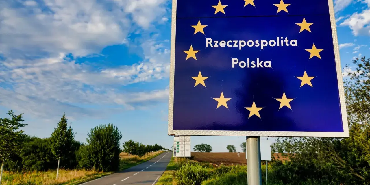 Granica Polski. Znak z gwiazdami Unii Europejskiej i napisem "Rzeczpospolita Polska". Droga prowadzi w głąb kraju, gdzie można złożyć wniosek o uchylenie zakazu opuszczania kraju.