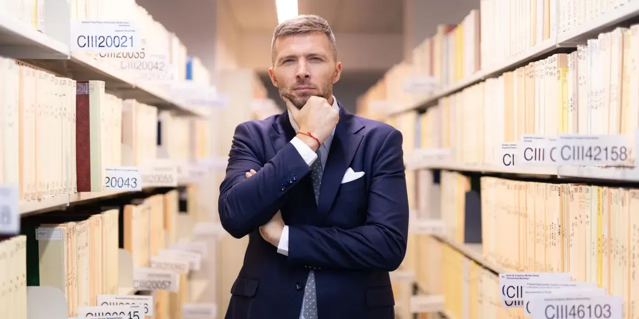 Mężczyzna w garniturze w archiwum, zastanawia się nad uchyleniem środka zapobiegawczego.
