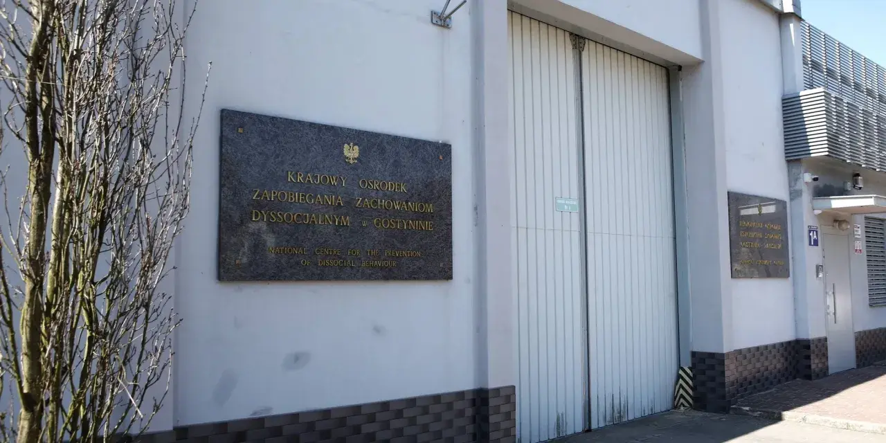 Tablica informacyjna przed budynkiem Krajowego Ośrodka Zapobiegania Zachowaniom Dyssocjalnym w Gostyninie.