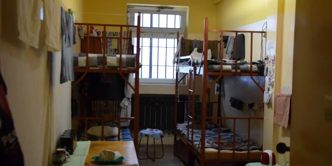 Tak wygląda cela w areszcie śledczym: dwa piętrowe łóżka, okno z kratami, stół z jedzeniem i suszące się ubrania.
