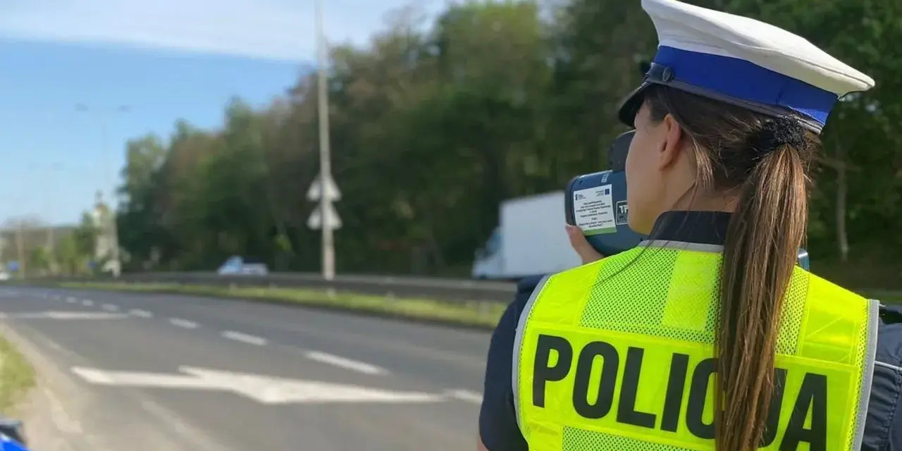 Policjantka w kamizelce odblaskowej mierzy prędkość pojazdów. Uważaj na tryb przyspieszony na drodze!