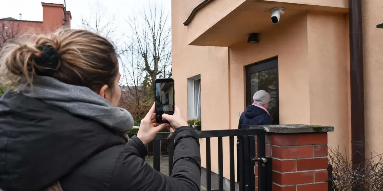 Kobieta nagrywa telefonem sytuację przed domem, zastanawiając się, czy nagranie z telefonu może być dowodem w sprawie karnej.