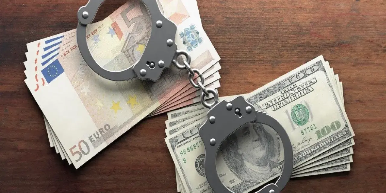 Kajdanki na stosach euro i dolarów. Symbolizują finansowe kk oszustwo i jego konsekwencje.