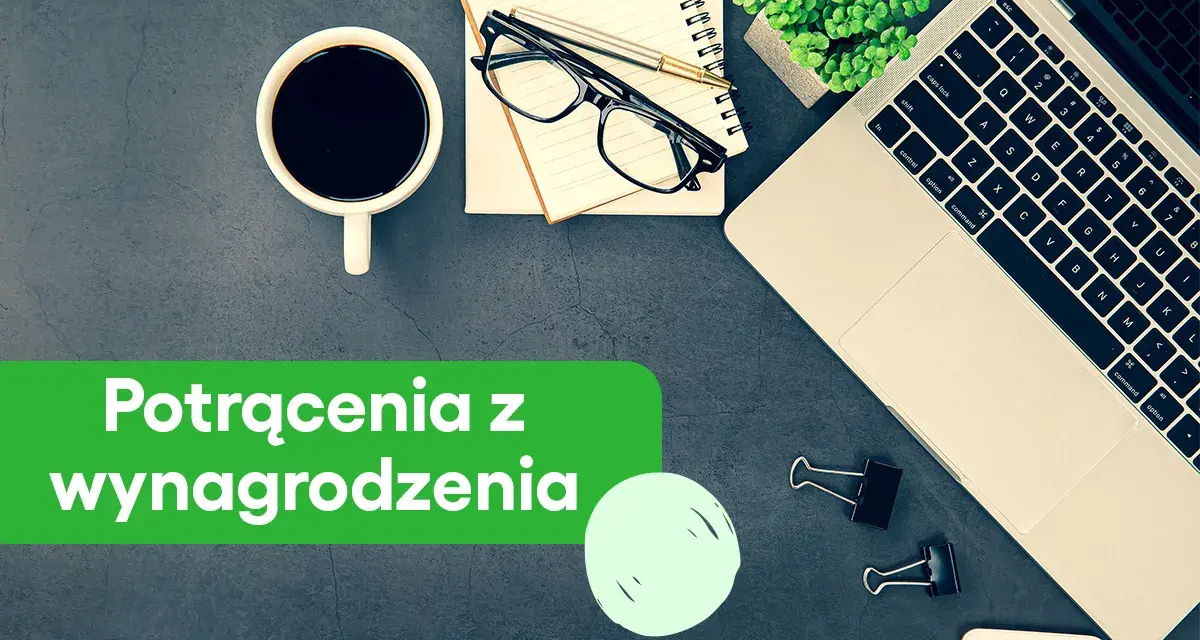 Biurko z laptopem, kawą i notatnikiem. Zielony baner informuje o potrąceniach z wynagrodzenia skazanego.