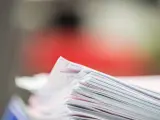 Stos dokumentów, potencjalne dowody rzeczowe w postępowaniu karnym, z czerwonym tłem.