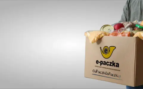 Mężczyzna niesie kartonowe pudełko z produktami spożywczymi, które jest częścią elektronicznej paczki żywnościowej.