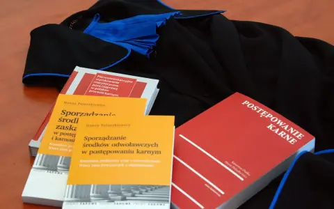 Książki o prawie karnym i togi prawnicze. Wiedza o prawach przysługujących oskarżonemu w sądzie jest kluczowa.