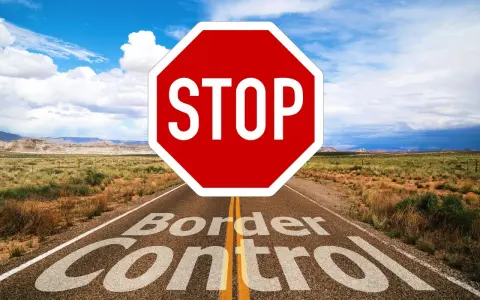 Droga prowadzi przez pustynny krajobraz, a na niej znak STOP i napis "Border Control". To symbol zakazu opuszczania kraju.