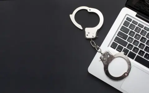 Kajdanki na klawiaturze laptopa, symbolizujące oświadczenie o podjęciu odbywania kary ograniczenia wolności wzór.