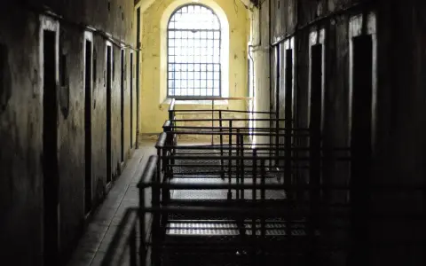 Korytarz więzienny z celami i kratami. Czekanie na decyzję sądu, po jakim czasie sąd wydaje nakaz doprowadzenia do zakładu karnego, może być długie.