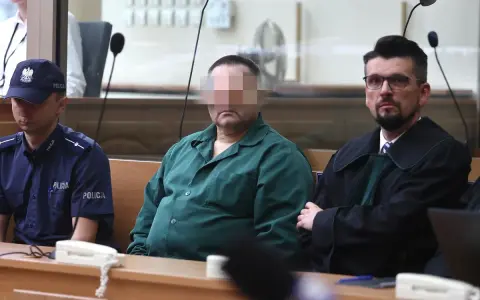 Oskarżony w zielonej koszuli, policjant i prawnik w togach. Czy rozprawa może się odbyć bez oskarżonego?