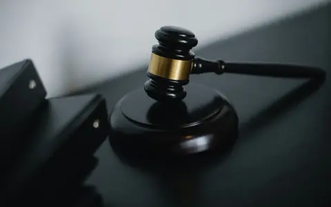 Młotek sędziowski i akta prawne symbolizują sprawiedliwość w sprawach o przestępstwo skarbowe.