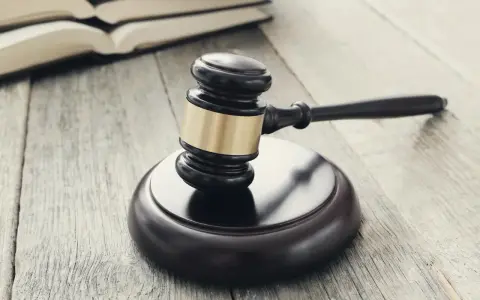 Młotek sędziowski i otwarte księgi. Może symbolizować wniosek o odroczenie wykonania kary, a nie tylko bilet do wolności.