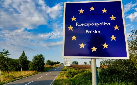 Granica Polski. Znak z gwiazdami Unii Europejskiej i napisem "Rzeczpospolita Polska". Droga prowadzi w głąb kraju, gdzie można złożyć wniosek o uchylenie zakazu opuszczania kraju.
