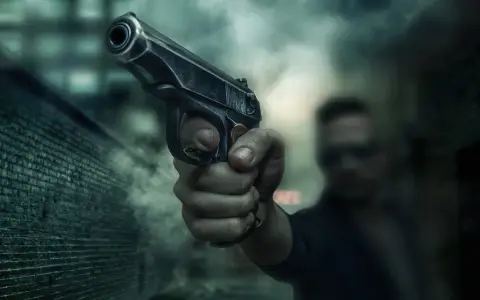Dłoń trzyma pistolet, gotowa do strzału. Scena sugeruje sytuację z art. 64 par. 2 kk, gdzie groźba użycia broni może być kluczowa.