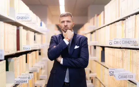 Mężczyzna w garniturze w archiwum, zastanawia się nad uchyleniem środka zapobiegawczego.