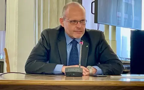 Mężczyzna w garniturze przy mikrofonie Philips. Dyskutuje, ile czasu ma prokurator na rozpatrzenie wniosku o widzenie.