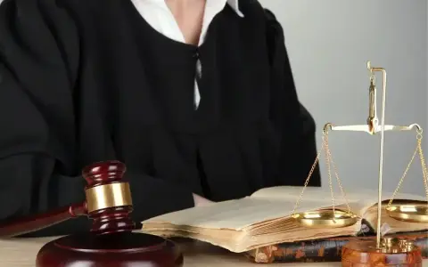 Sędzia w todze, młotek, waga sprawiedliwości i księgi symbolizują prawo i nadzwyczajne środki zaskarżenia.