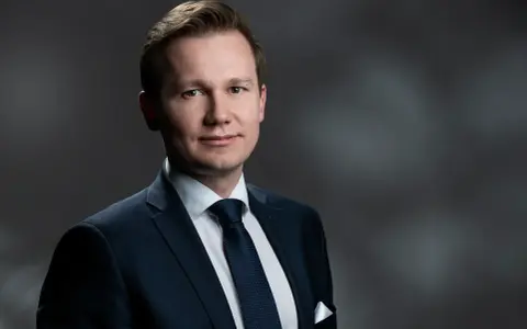 Mężczyzna w garniturze, gotowy do przesłuchania w charakterze świadka.
