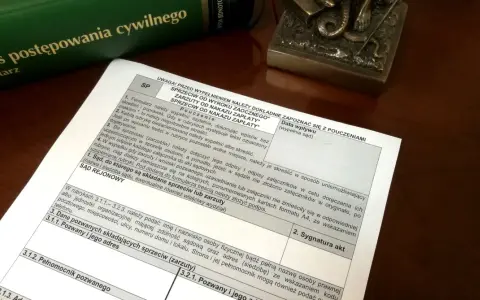 Dokument z pouczeniami do wypełnienia sprzeciwu od wyroku zaocznego lub nakazu zapłaty, obok zielonej księgi "Kodeks postępowania cywilnego".