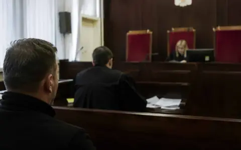 W sali sądowej mężczyzna czeka na rozprawę. Ile trwa sprawa karna?