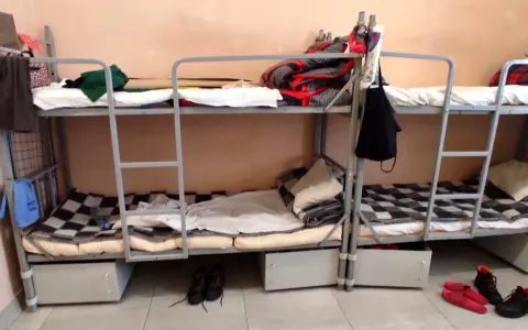 Tak wygląda dzień w areszcie śledczym: piętrowe łóżka, koce, poduszki i buty na podłodze.