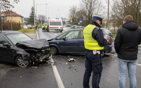 Policjant spisuje notatki po wypadku drogowym. Uszkodzone samochody, art. 177 kk.