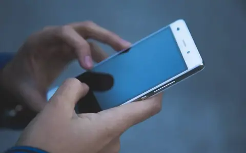 Dłonie trzymają smartfon, który może posłużyć jako telefon jako dowód w sprawie.