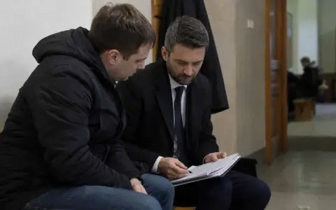 Prawnik omawia z klientem dokumenty dotyczące dobrowolnego poddania się karze a warunkowego umorzenia postępowania.