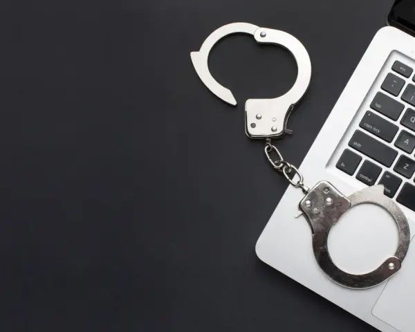 Kajdanki na klawiaturze laptopa, symbolizujące oświadczenie o podjęciu odbywania kary ograniczenia wolności wzór.