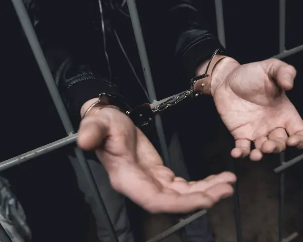 Ręce w kajdankach za kratami. Historia o tym, kiedy policja ściga za alimenty, kończy się zatrzymaniem.