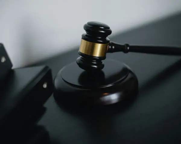 Młotek sędziowski i akta prawne symbolizują sprawiedliwość w sprawach o przestępstwo skarbowe.